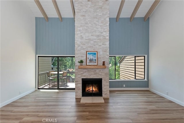 27657 Peninsula Dr Unit 131, Lake Arrowhead, CA 92352 - unfurnished living room featuring high vaulted ceiling, a stone fireplace, wood finished floors, a wooden ceiling with exposed beams, and wood walls