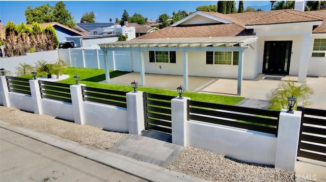 7401 Liberty Ave, Corona, CA 92881 - view of front of property featuring a shingled roof, a fenced front yard, stucco siding, and a gate