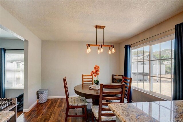 24920 Via Lopez Ct, Ramona, CA 92065 - dining room featuring dark wood-style flooring, a textured ceiling, a chandelier, and baseboards