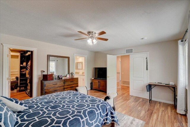 24920 Via Lopez Ct, Ramona, CA 92065 - bedroom with light wood finished floors, a spacious closet, a closet, a textured ceiling, and a ceiling fan