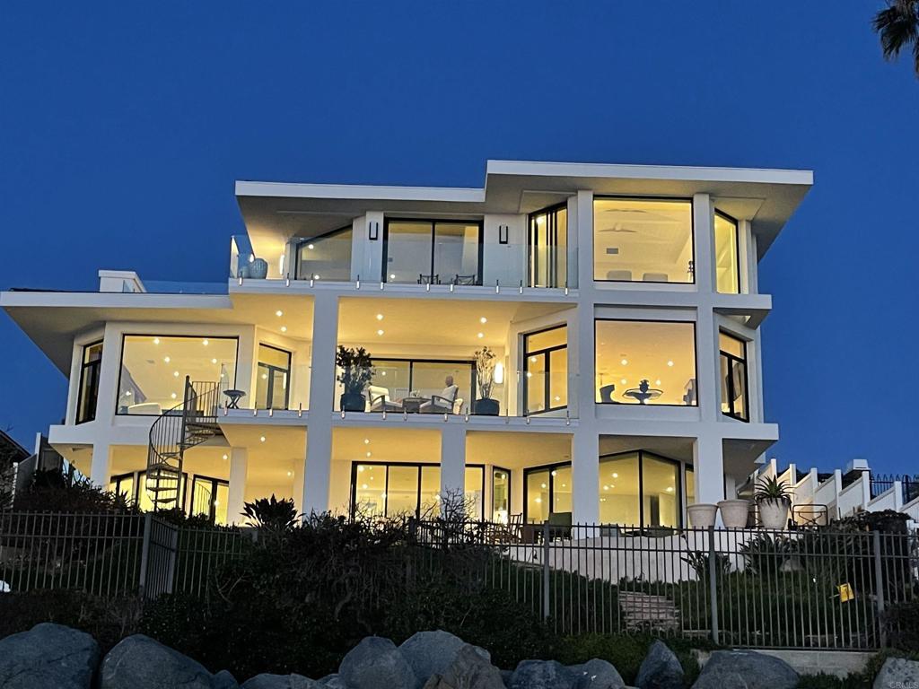 5067 Shore Dr, Carlsbad, CA 92008 - back of house at twilight featuring a balcony and stucco siding