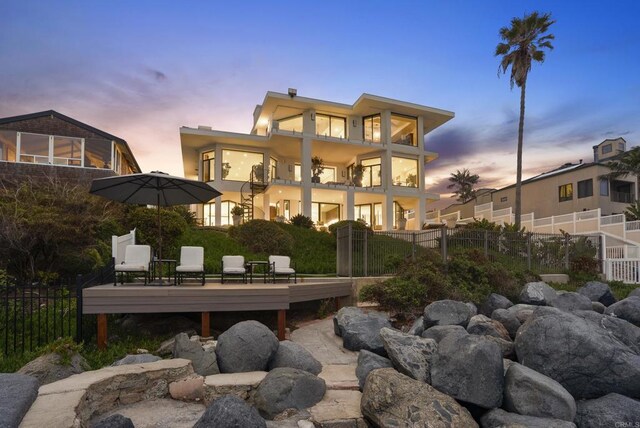 5067 Shore Dr, Carlsbad, CA 92008 - back of property at dusk featuring a balcony and a deck