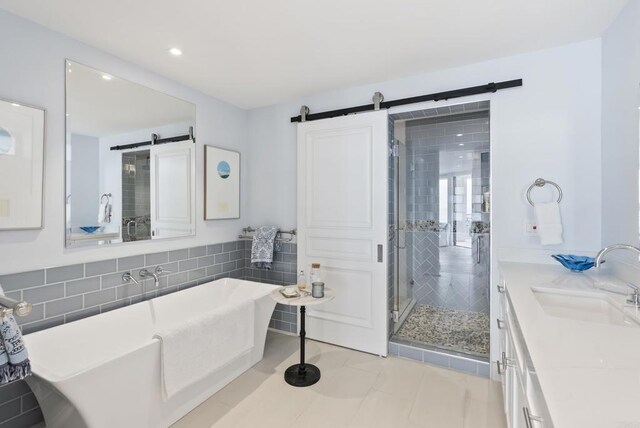 5067 Shore Dr, Carlsbad, CA 92008 - bathroom featuring a soaking tub, a stall shower, double vanity, recessed lighting, and tile patterned flooring