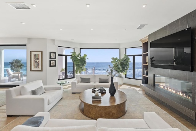 5067 Shore Dr, Carlsbad, CA 92008 - living area featuring healthy amount of natural light, a large fireplace, recessed lighting, and wood finished floors