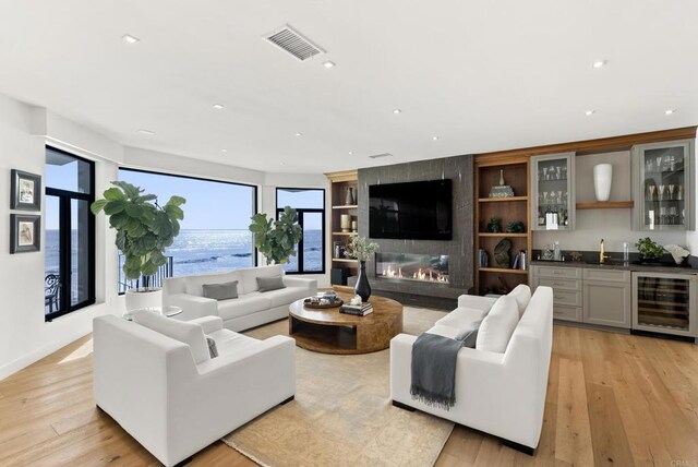 5067 Shore Dr, Carlsbad, CA 92008 - living area featuring beverage cooler, wet bar, light wood-type flooring, recessed lighting, and a fireplace