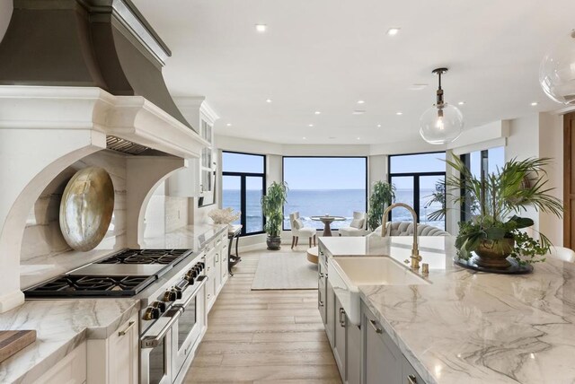 5067 Shore Dr, Carlsbad, CA 92008 - kitchen featuring double oven range, custom range hood, recessed lighting, light stone countertops, and light wood finished floors