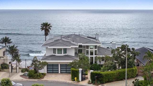 5067 Shore Dr, Carlsbad, CA 92008 - view of front of house featuring a water view, a garage, a tile roof, stucco siding, and driveway