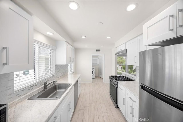 17435 Lassen St, Northridge, CA 91325 - kitchen featuring stainless steel appliances, a sink, washer / dryer, baseboards, and white cabinetry