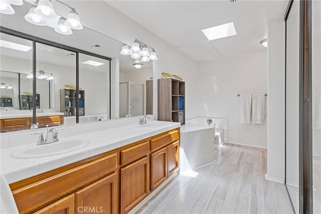 40612 Via Amapola, Murrieta, CA 92562 - full bathroom featuring a stall shower, wood finished floors, double vanity, and a skylight