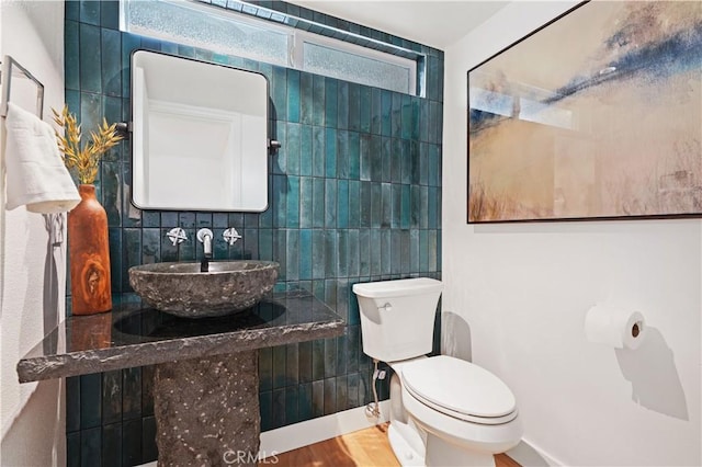 64 Sandpiper Unit 28, Irvine, CA 92604 - half bath featuring a sink, toilet, wood finished floors, and tile walls