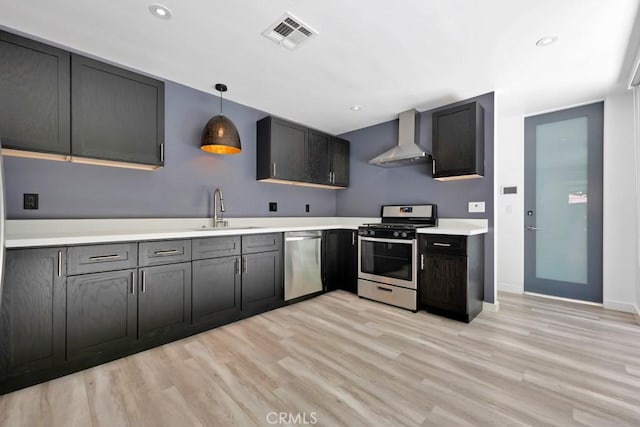11230 Dilling St, Studio City, CA 91602 - kitchen featuring stainless steel appliances, wall chimney exhaust hood, a sink, light countertops, and light wood-style floors