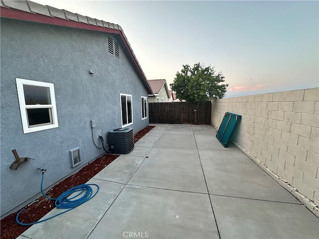 618 Award Dr, Colton, CA 92324 - property exterior at dusk with stucco siding, a fenced backyard, a patio area, and central AC unit