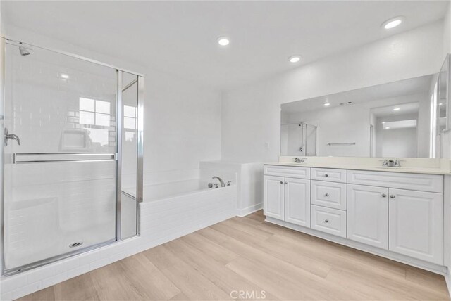 4742 S Scott Way, Ontario, CA 91762 - full bathroom featuring double vanity, a garden tub, a stall shower, wood finished floors, and recessed lighting