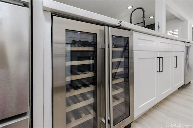 1222 W Kettering St, Lancaster, CA 93534 - kitchen view of beverage cooler, white cabinetry, recessed lighting, and light wood-style flooring