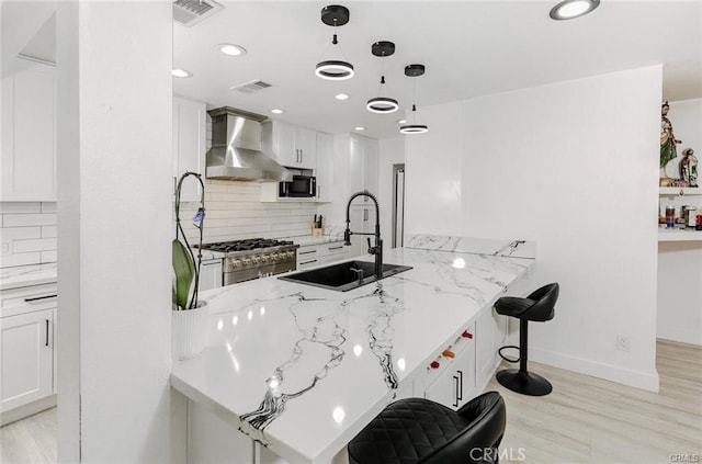 1222 W Kettering St, Lancaster, CA 93534 - kitchen with wall chimney exhaust hood, range, light stone countertops, tasteful backsplash, and recessed lighting