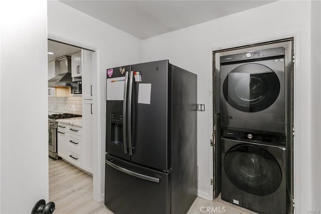 1222 W Kettering St, Lancaster, CA 93534 - laundry area featuring stacked washer and clothes dryer and light wood-style flooring