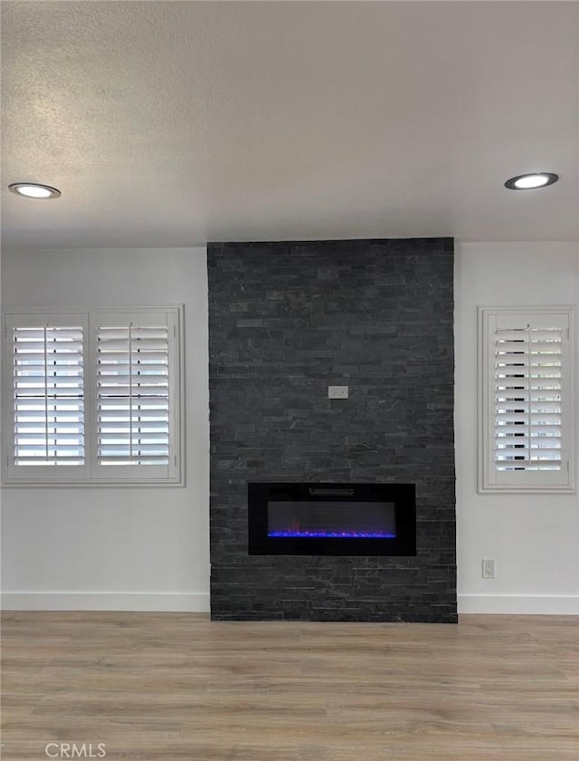 1222 W Kettering St, Lancaster, CA 93534 - detailed view of wood finished floors, a stone fireplace, and recessed lighting