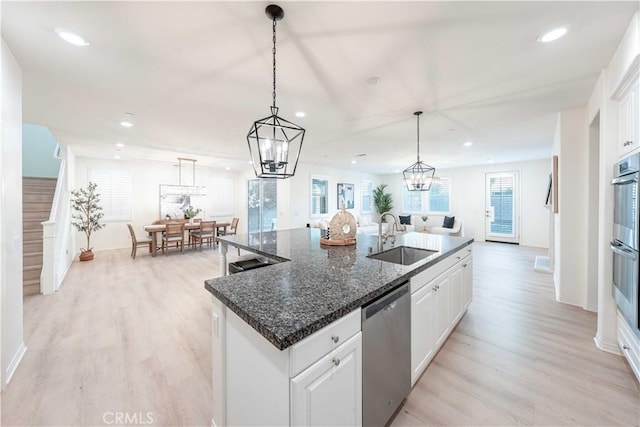 6940 Lagoon Ct, Jurupa Valley, CA 91752 - kitchen with stainless steel appliances, recessed lighting, a kitchen island with sink, white cabinets, and light wood-style flooring
