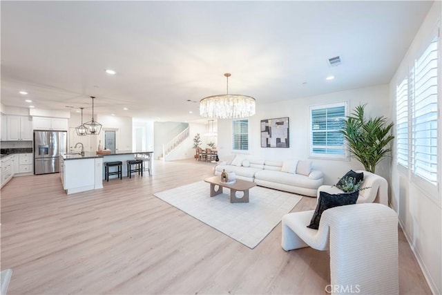 6940 Lagoon Ct, Jurupa Valley, CA 91752 - living area with a chandelier, stairway, recessed lighting, and light wood finished floors