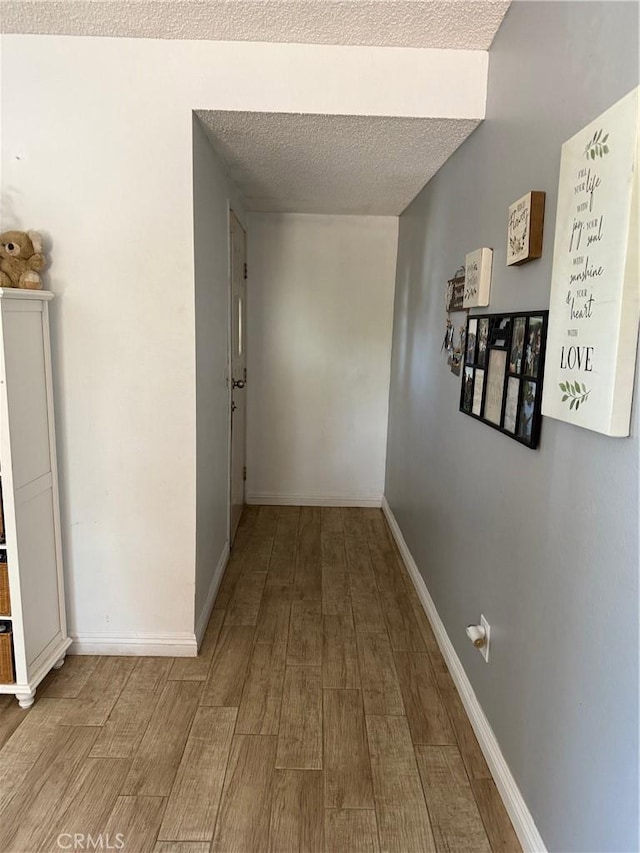 13484 Franceska Rd, Apple Valley, CA 92308 - hallway featuring wood finished floors, a textured ceiling, and baseboards