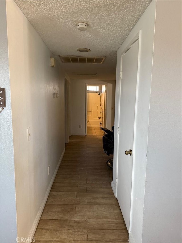 13484 Franceska Rd, Apple Valley, CA 92308 - hallway featuring light wood-style floors, a textured ceiling, and baseboards