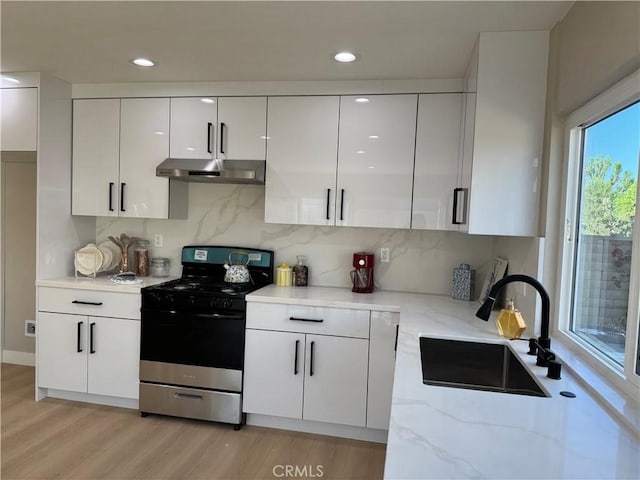 135 Ricci Ave, Walnut, CA 91789 - kitchen featuring gas stove, under cabinet range hood, a sink, white cabinetry, and recessed lighting