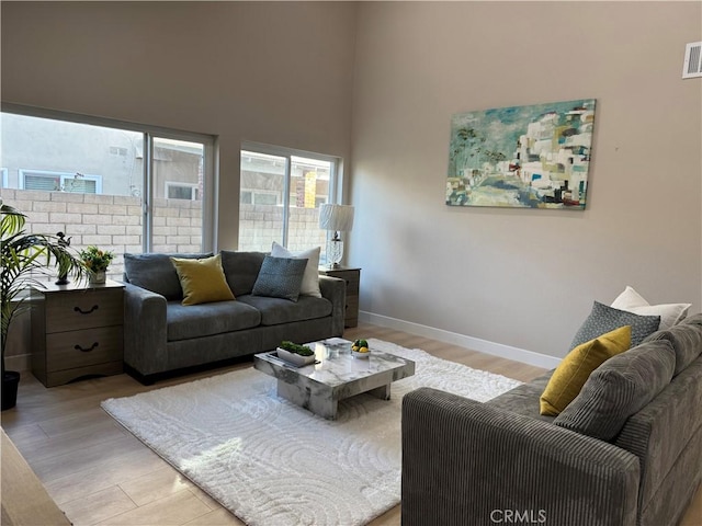 135 Ricci Ave, Walnut, CA 91789 - living room with light wood-style floors, baseboards, and a high ceiling