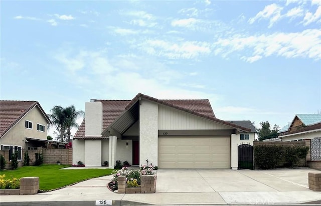 135 Ricci Ave, Walnut, CA 91789 - view of front facade with a tiled roof, an attached garage, driveway, stucco siding, and a chimney
