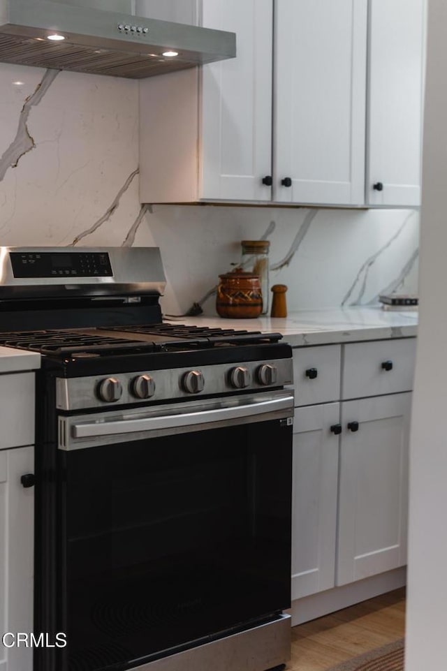 3538 Sierra St, Los Angeles, CA 90031 - kitchen featuring gas range, under cabinet range hood, white cabinets, light stone counters, and decorative backsplash