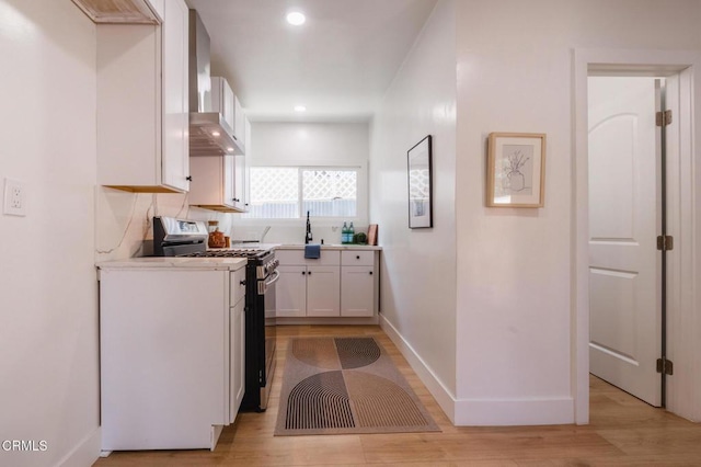 3538 Sierra St, Los Angeles, CA 90031 - kitchen with gas range, wall chimney exhaust hood, white cabinets, baseboards, and light countertops