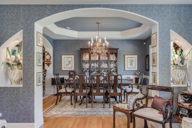 4014 Millagra Dr, Fallbrook, CA 92028 - dining room featuring arched walkways, a chandelier, wood finished floors, crown molding, and a raised ceiling