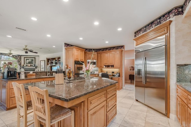 4014 Millagra Dr, Fallbrook, CA 92028 - kitchen with built in appliances, a sink, a kitchen island, dark stone counters, and a ceiling fan