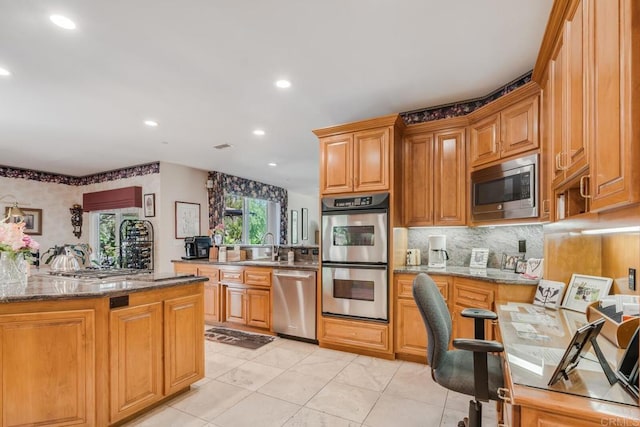 4014 Millagra Dr, Fallbrook, CA 92028 - kitchen with appliances with stainless steel finishes, dark stone countertops, tasteful backsplash, recessed lighting, and brown cabinets