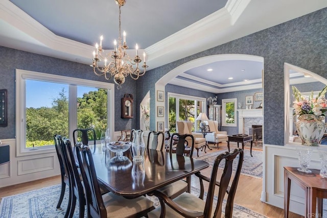 4014 Millagra Dr, Fallbrook, CA 92028 - dining area with arched walkways, a tray ceiling, crown molding, wallpapered walls, and light wood-style flooring