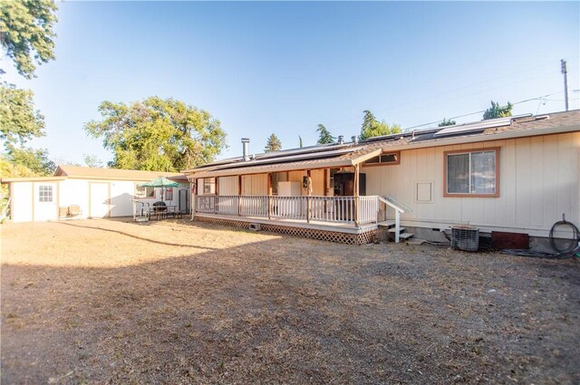 13182 Third St, Clearlake Oaks, CA 95423 - view of front of home with solar panels, cooling unit, an outdoor structure, and a deck