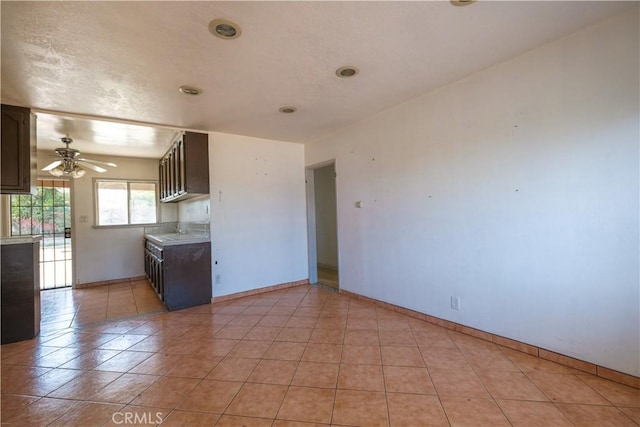 7227 Farmland Ave, Pico Rivera, CA 90660 - kitchen featuring baseboards, dark brown cabinetry, a ceiling fan, light countertops, and light tile patterned flooring