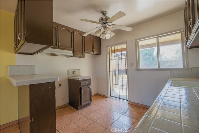 7227 Farmland Ave, Pico Rivera, CA 90660 - kitchen featuring tile countertops, dark brown cabinetry, a ceiling fan, baseboards, and light tile patterned floors