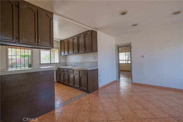 7227 Farmland Ave, Pico Rivera, CA 90660 - kitchen with light countertops, dark brown cabinets, light tile patterned floors, and a sink