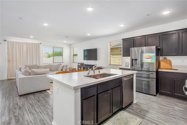 1737 Arcus Ct, Beaumont, CA 92223 - kitchen featuring stainless steel appliances, a sink, light wood-style floors, light countertops, and a kitchen island with sink