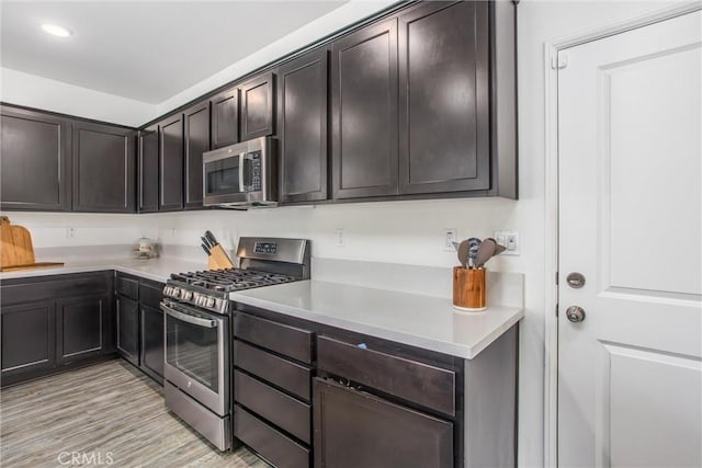 1737 Arcus Ct, Beaumont, CA 92223 - kitchen featuring appliances with stainless steel finishes, light countertops, dark brown cabinets, light wood-style flooring, and recessed lighting