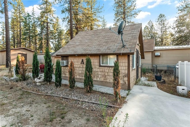 59485 State Highway 74, Mountain Center, CA 92561 - view of home's exterior featuring roof with shingles, cooling unit, an outbuilding, and a patio area