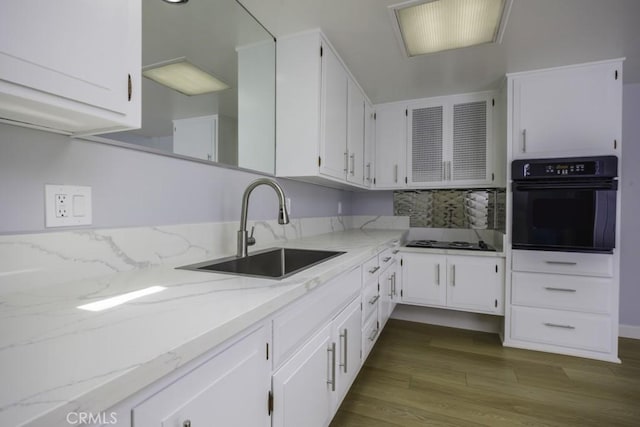 13881 Thunderbird Dr Unit M1-63E, Seal Beach, CA 90740 - kitchen featuring black appliances, a sink, dark wood-style floors, white cabinetry, and light stone countertops