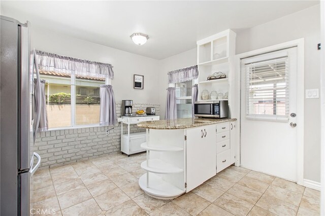 5342 Kingsley St, Montclair, CA 91763 - kitchen with open shelves, appliances with stainless steel finishes, white cabinets, light stone counters, and a peninsula