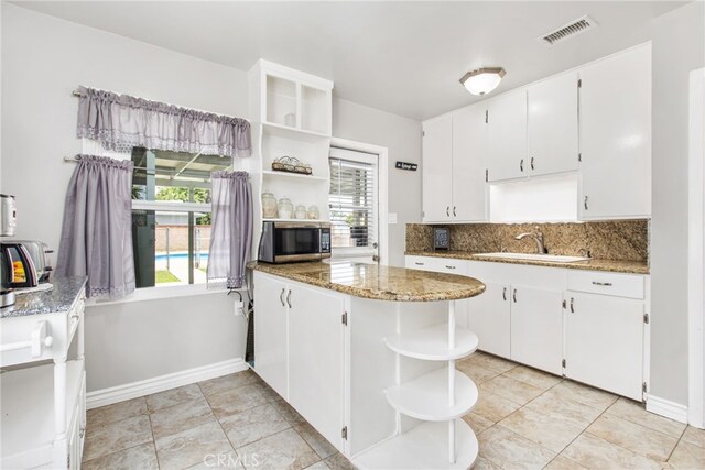 5342 Kingsley St, Montclair, CA 91763 - kitchen with open shelves, stainless steel microwave, white cabinetry, and plenty of natural light