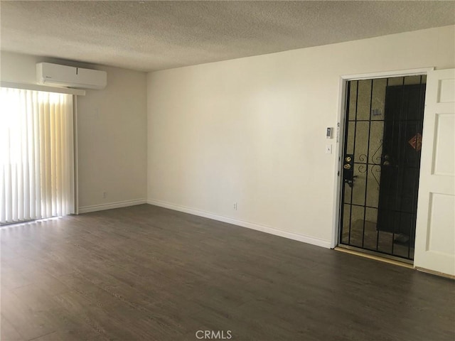 218 N Nicholson Ave, Monterey Park, CA 91755 - unfurnished room featuring a wall mounted AC, dark wood-style flooring, healthy amount of natural light, baseboards, and a textured ceiling