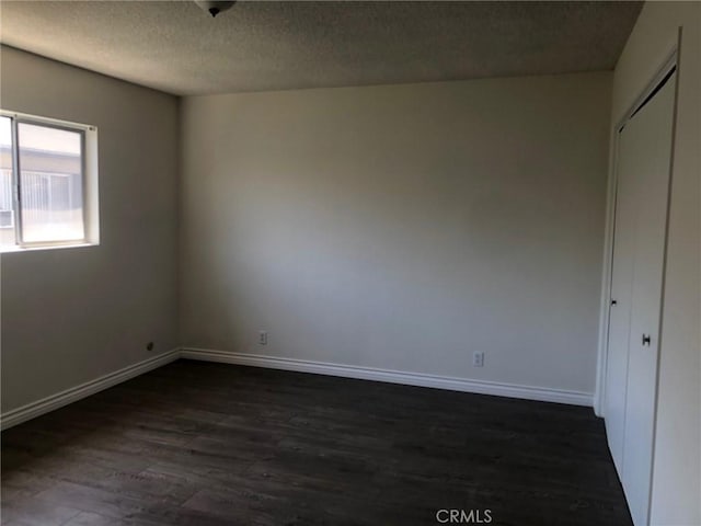 218 N Nicholson Ave, Monterey Park, CA 91755 - unfurnished bedroom featuring dark wood-style floors, a textured ceiling, baseboards, and a closet