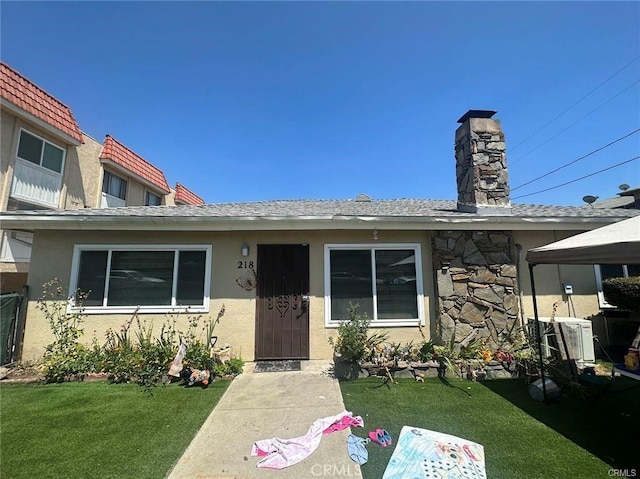 218 N Nicholson Ave, Monterey Park, CA 91755 - view of front of house with a front lawn, a chimney, central AC, and stucco siding