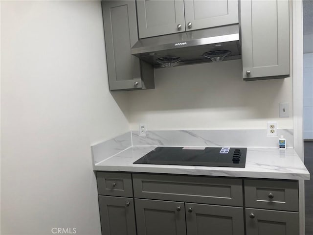 218 N Nicholson Ave, Monterey Park, CA 91755 - kitchen with under cabinet range hood, black electric cooktop, and gray cabinetry