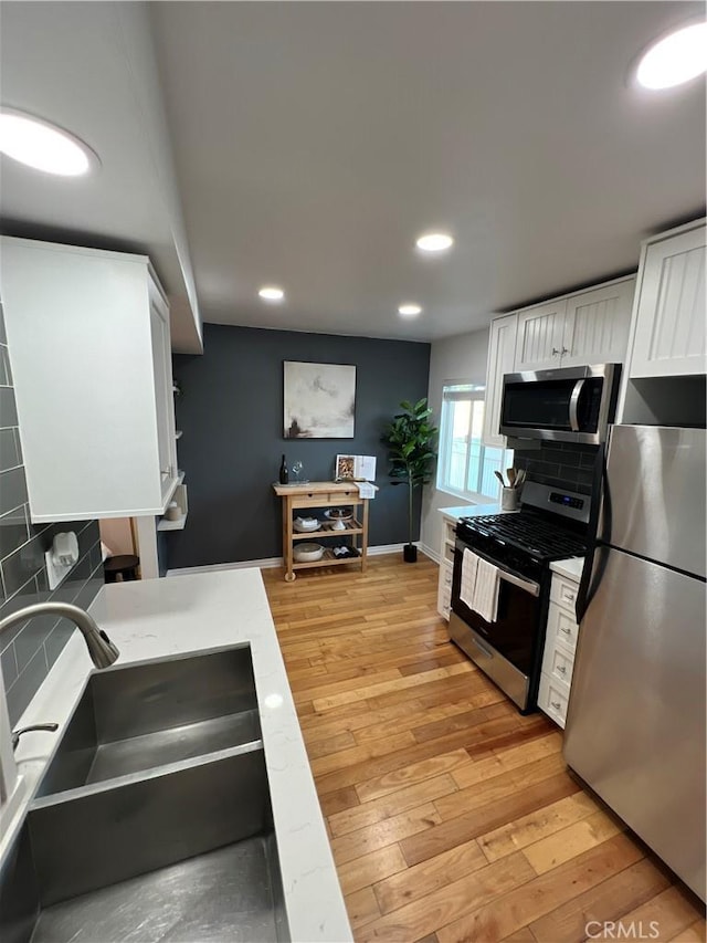 4113 E 10th St Unit 2, Long Beach, CA 90804 - kitchen featuring appliances with stainless steel finishes, white cabinetry, decorative backsplash, recessed lighting, and a sink