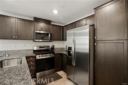 7155 Citrus Ave Unit 320, Fontana, CA 92336 - kitchen featuring stainless steel appliances, dark brown cabinetry, light stone countertops, light wood-style flooring, and recessed lighting